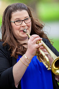 Headshot of Dr. Allyson Keyser playing a trumpet.