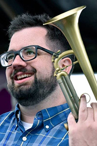 Headshot of Dylan Canterbury, holding a trumpet.