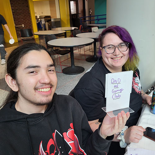 D&D and Gaming Club members holding up a sign for their club. 