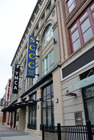 Exterior photo of State Street, Schenectady, looking down the sidewalk. Exterior of the buildings are on the right and visible is the SCCC sign.