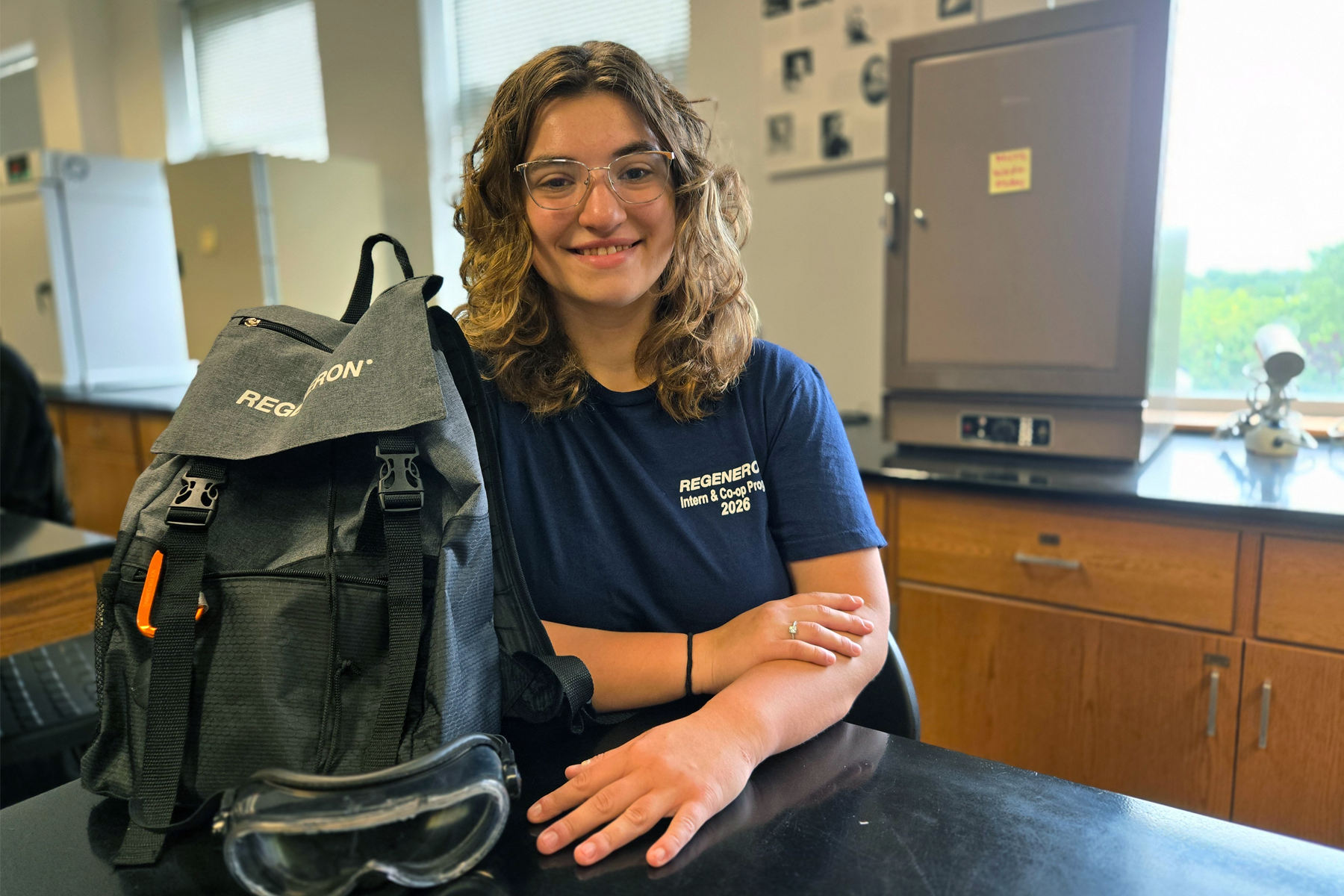 Evangeline Green with Regeneron backpack, sitting at table in Science Lab