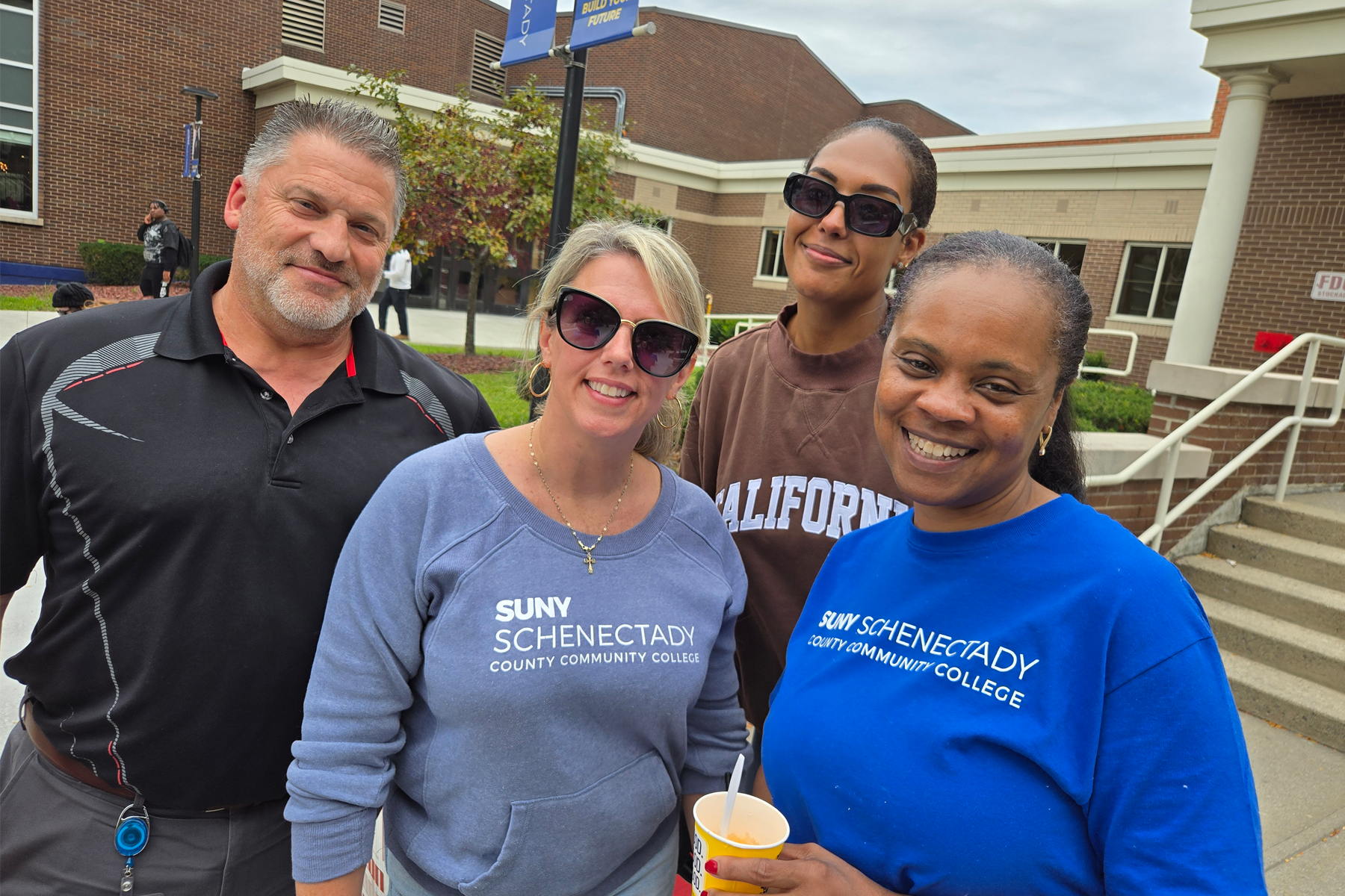 Staff members standing in The Quad, smiling