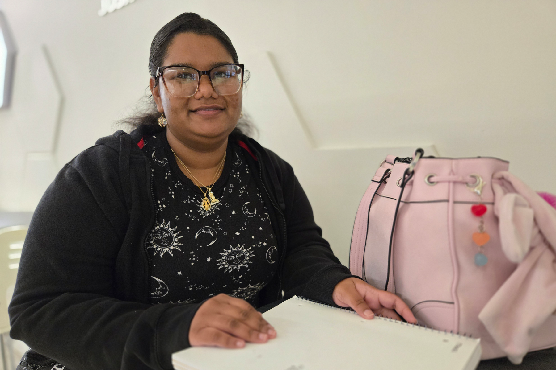Neha Khani sitting at table, smiling