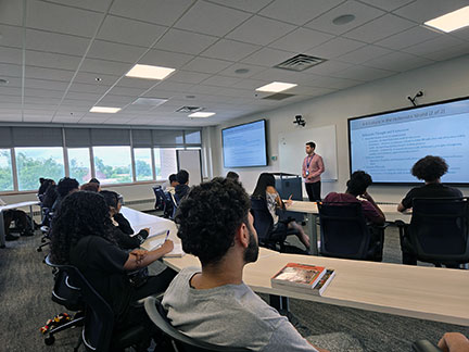 ECHS students in a classroom, a professor at the front of the room.