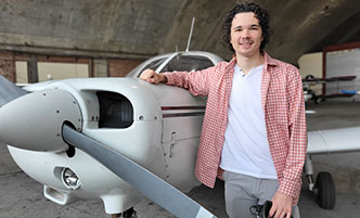 Jonathan Ryan in front of a small airplane.