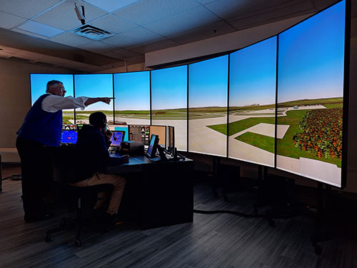 Faculty member working with a student in the ATC simulator.
