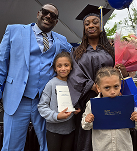 2025 graduate with her partner and two children.