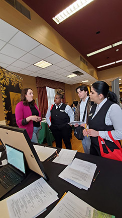 HCAT students talking to a recruiter at a career fair.