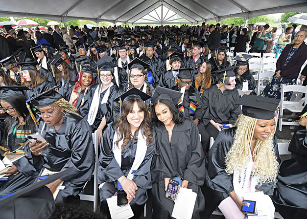 A broad view of the graduates and guests seated under the tent at Commencement.