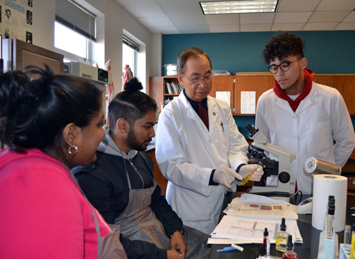 Professor Renato Tameta in a science lab with three students.