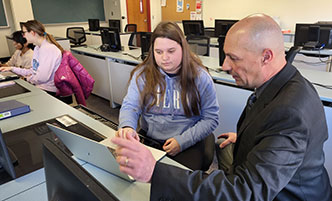 Faculty member speaking with a student in the Montessori Laboratory Classroom.