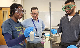 Two students looking into microscopes in the biotechnology lab.