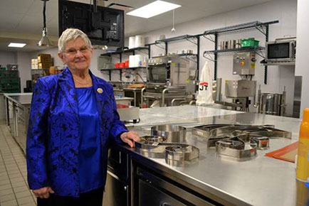 Joan Dembinski '10, standing in the Chocolate and Confections Lab that was named in her honor.