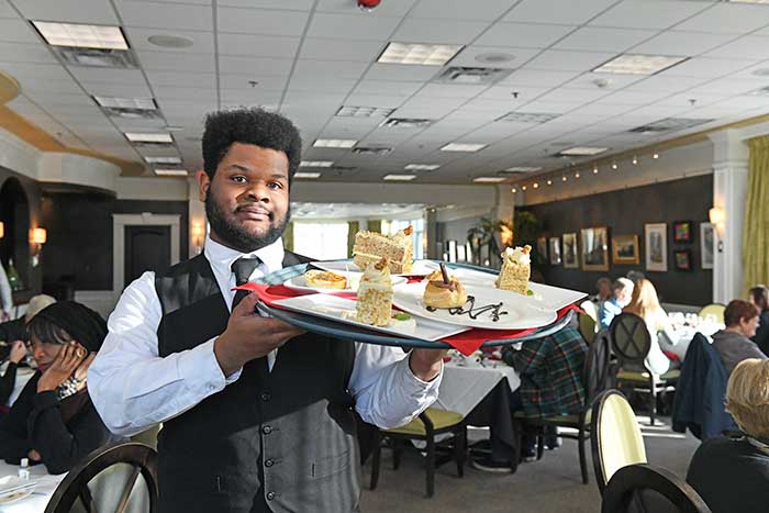 Hotel and Restaurant Management student working in the Casola Dining Room.