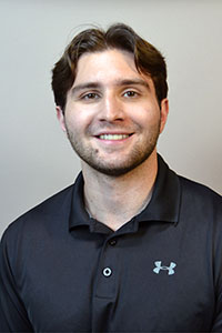 Headshot of Damian Bruce, wearing a black polo shirt. 
