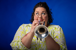 Headshot of Dr. Jennifer Oliverio holding a trumpet.