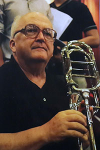 Headshot of Phil Brink holding a trombone.