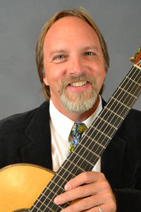 Music professor Sten Isachsen holding a guitar.