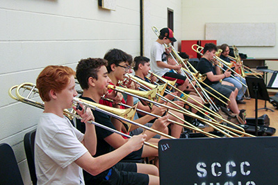 Students at the 2024 Trombone Camp, all playing trombones.