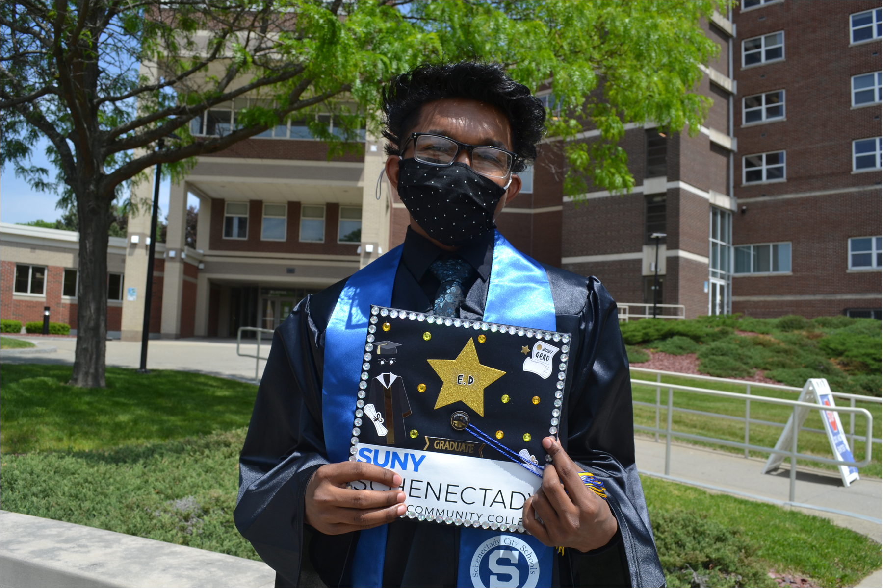 Smart Transfer graduate in cap and gown outside at SUNY Schenectady