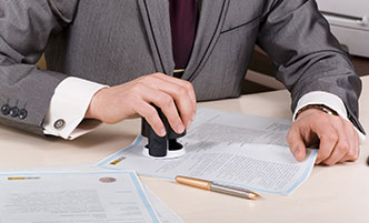 Close up shot of a notary stamping a document.