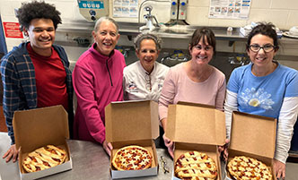 Group of culinary students and instructor with finished pies.