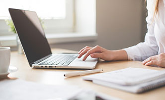 Overhead shot of a person typing on a laptop.