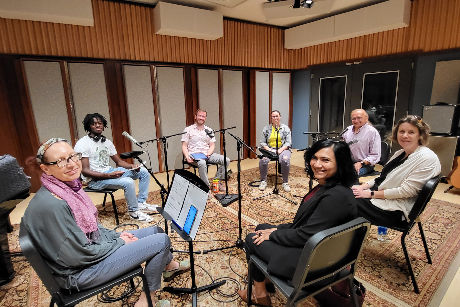 Podcast participants sitting in recording studio near microphones