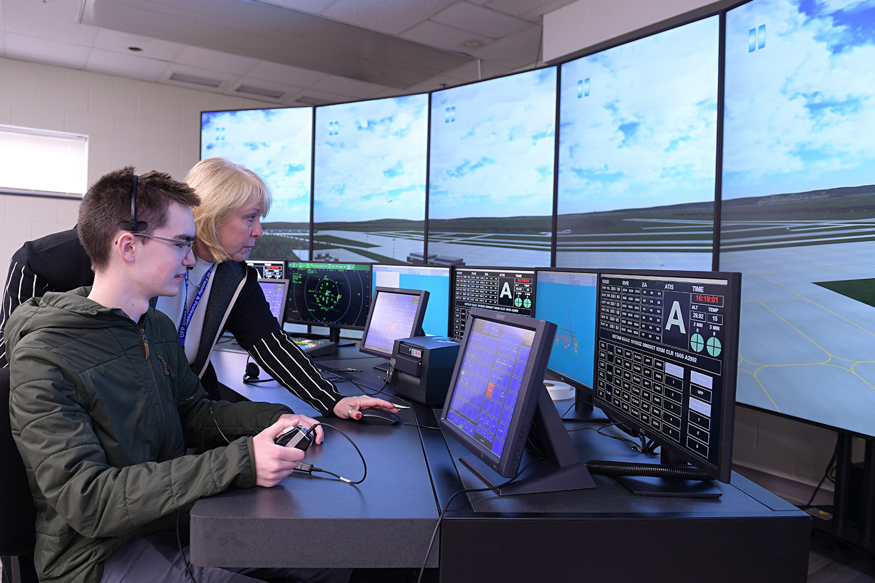 Faculty member and student using the air traffic control simulator