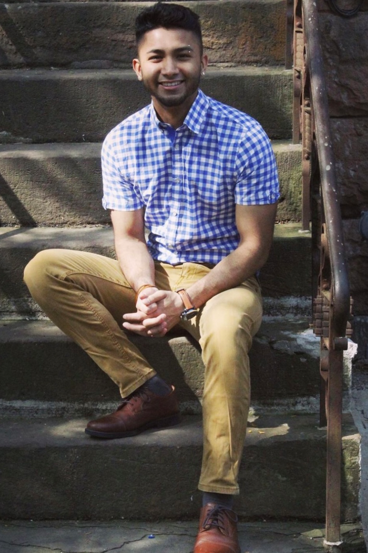 Abhishek Sharma sitting outside on steps, smiling