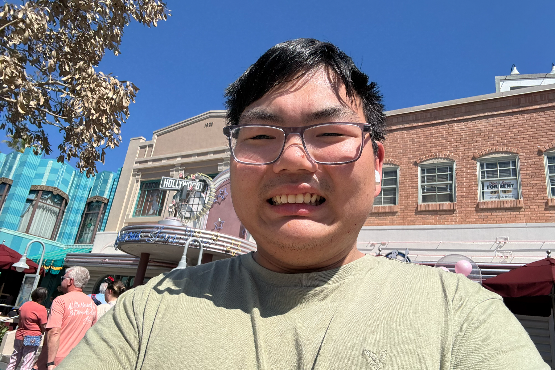 Aidan Collins smiling, standing in front of Hollywood & Vine Restaurant, Disney World