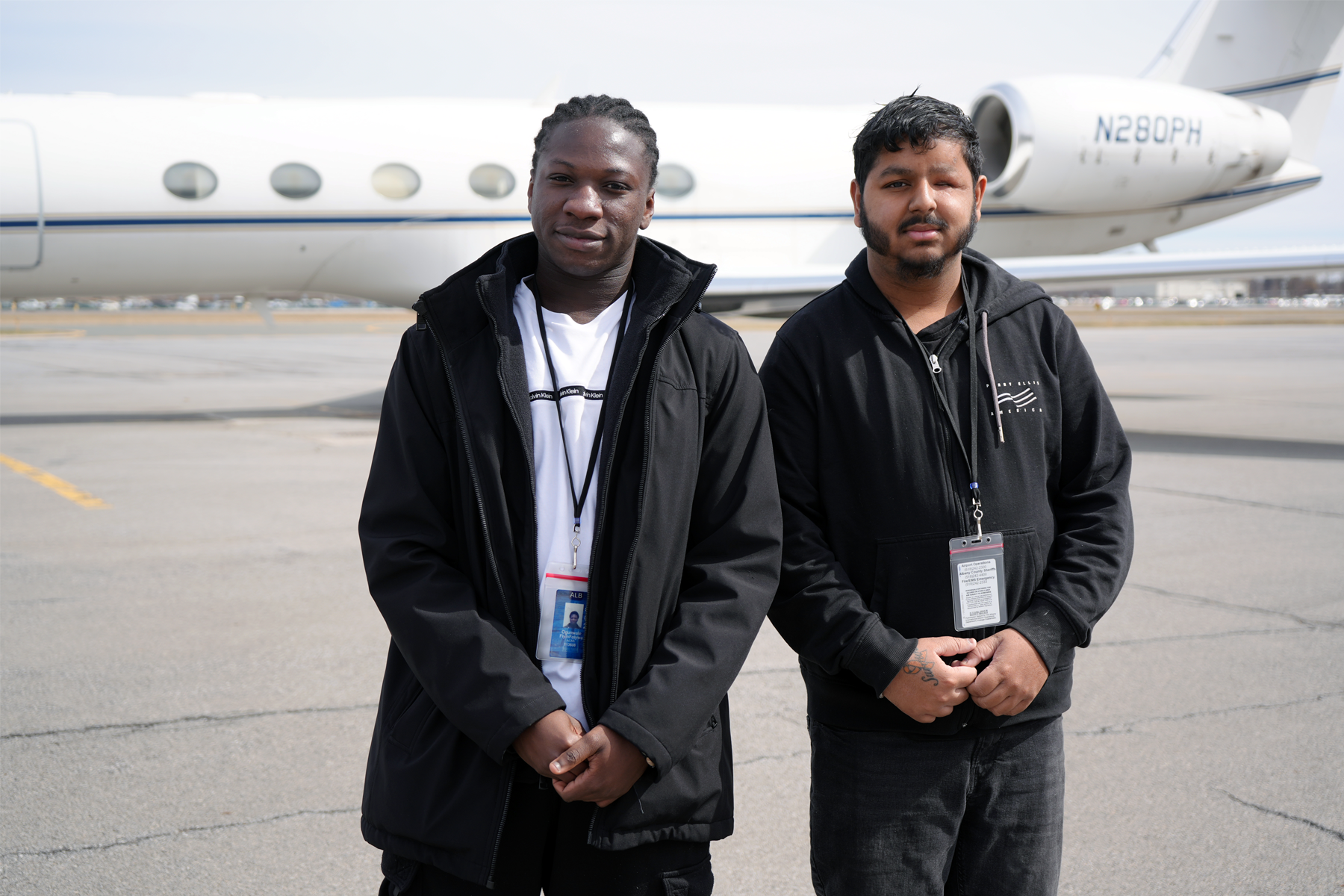 Fiyinfoluwa Ogunwale and Jonathan Bridgnanan standing in front of airplane at airport