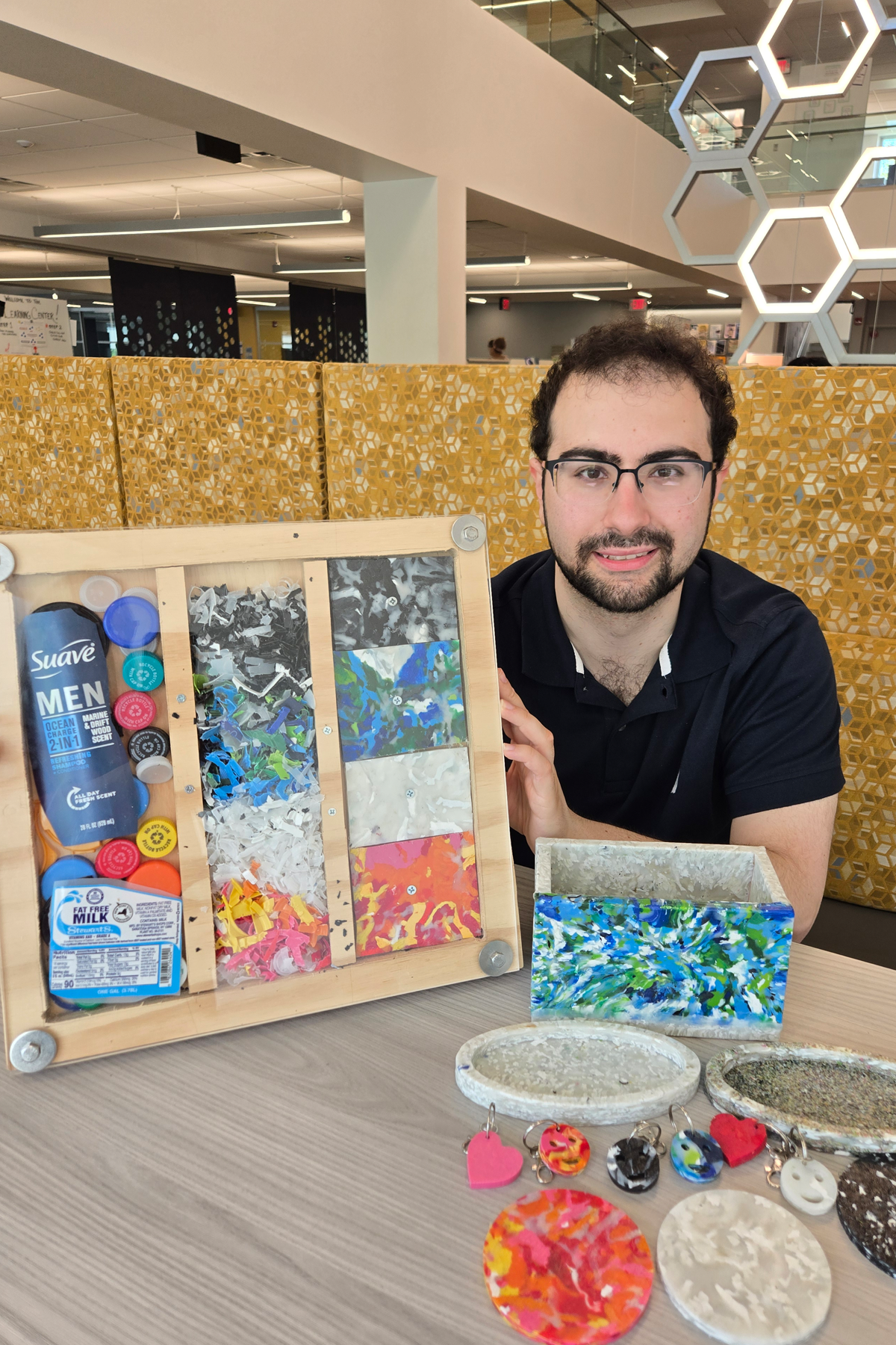 Alex Graziano holding display case of recycled products