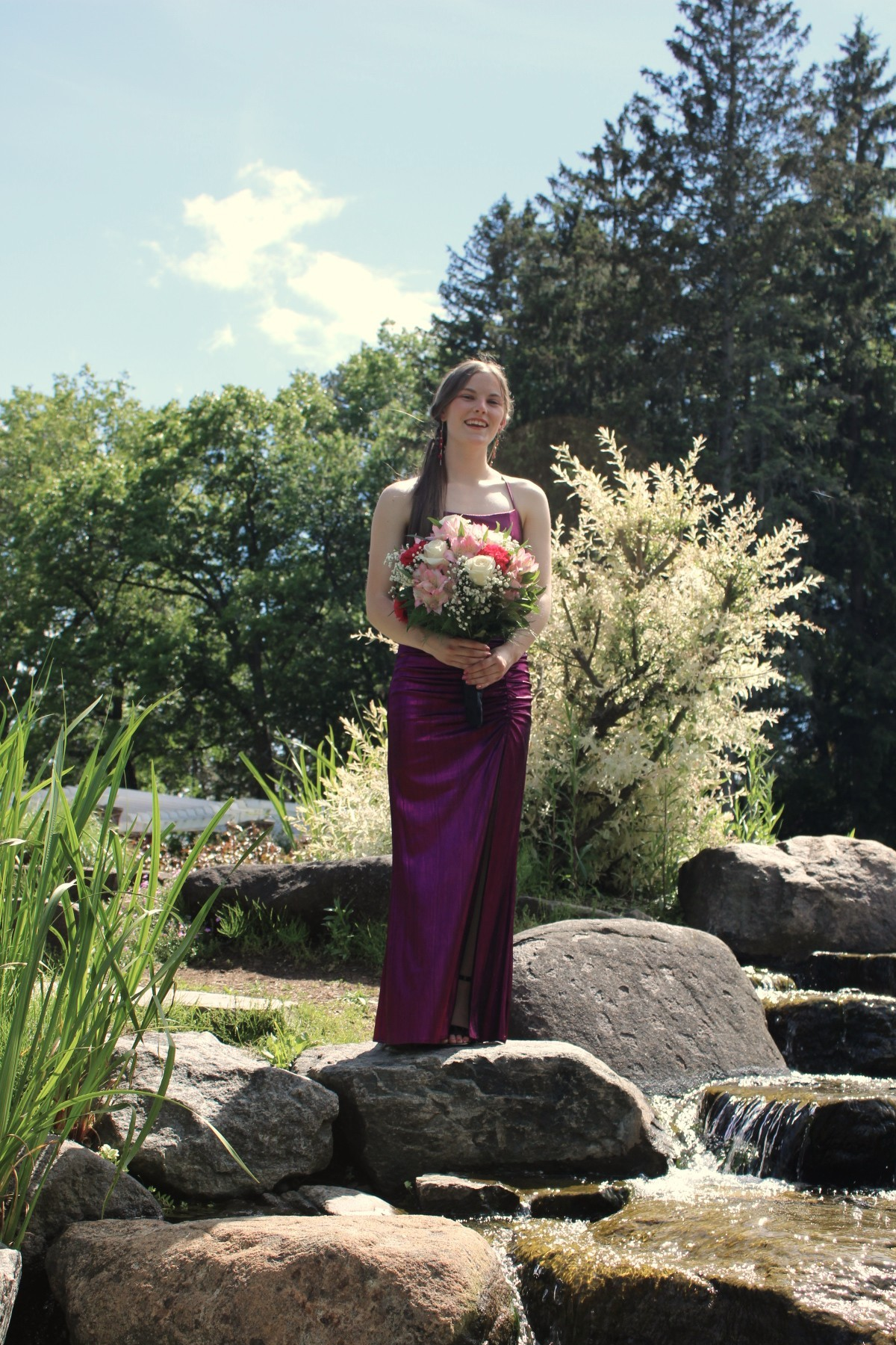 Alexis Thayer wearing formal dress, standing outside, smiling