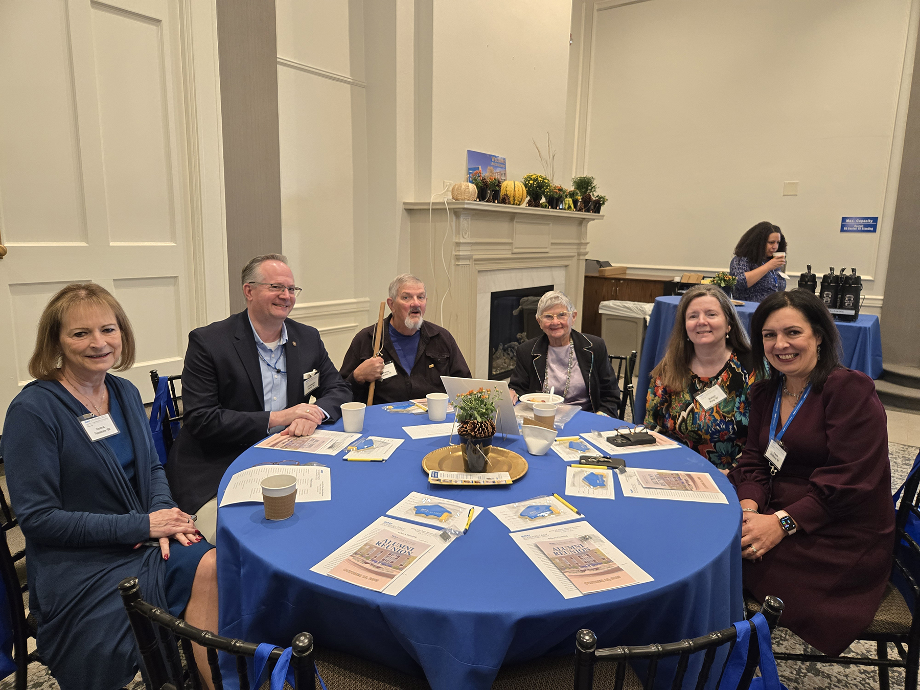 Alumni group seated at table, smiling