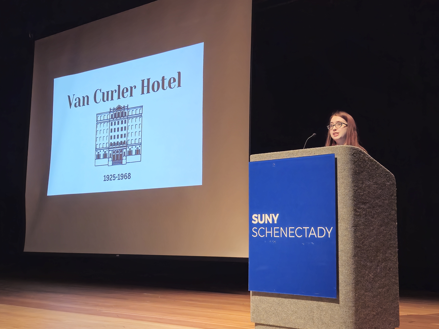 Grace Ferris speaking at podium in auditorium