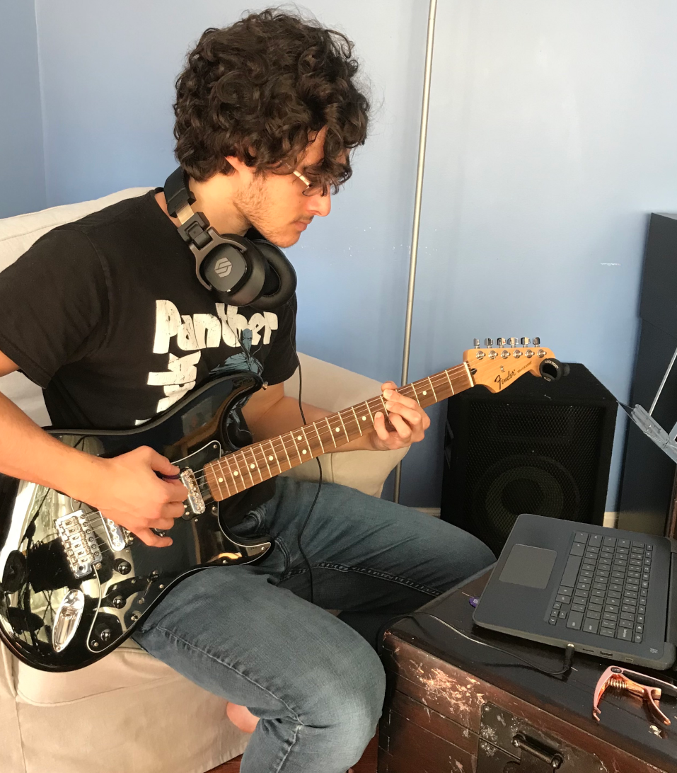 Antonio Cordova at home playing electric guitar.