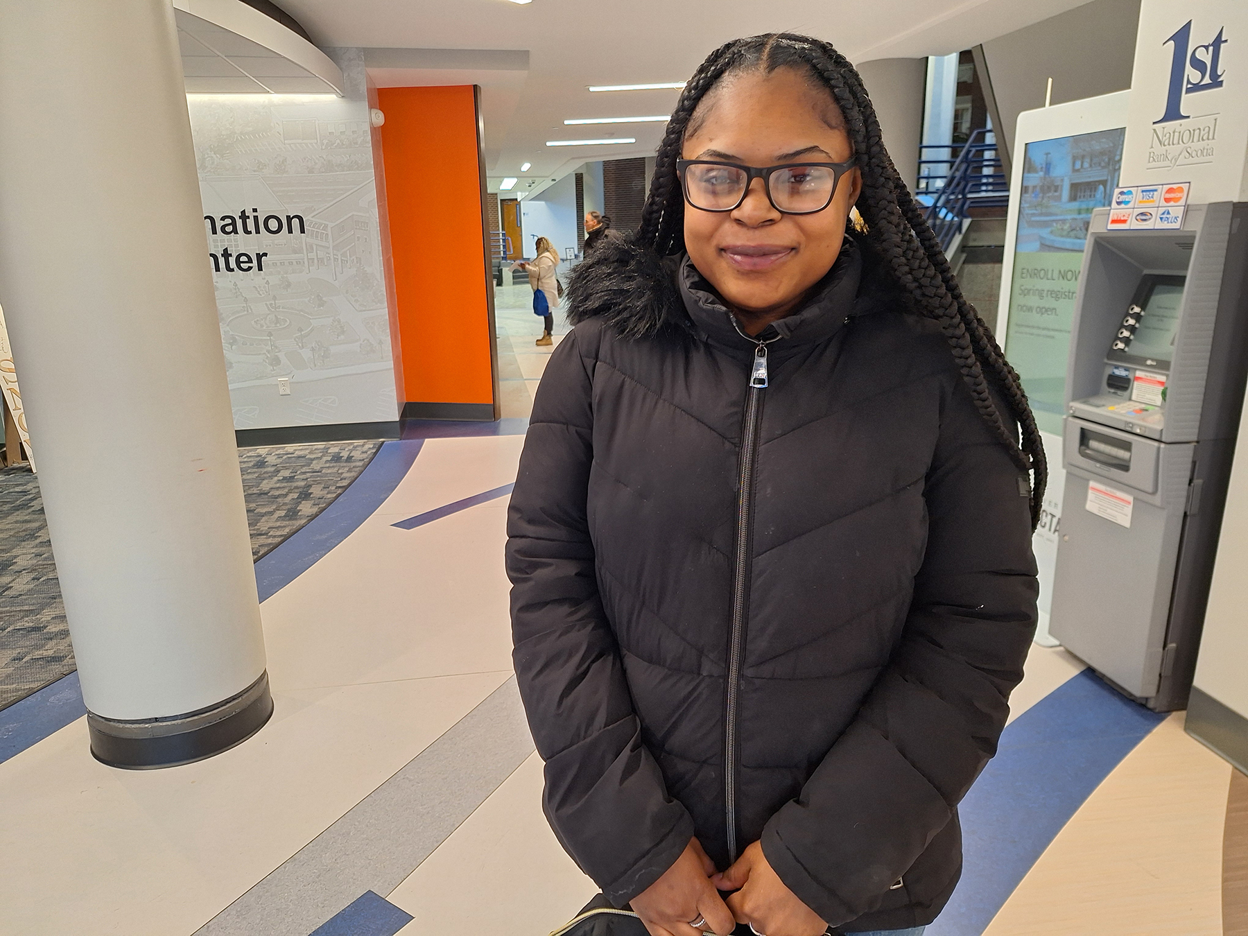 Asahdia Thompson standing in Welcome Center lobby, smiling