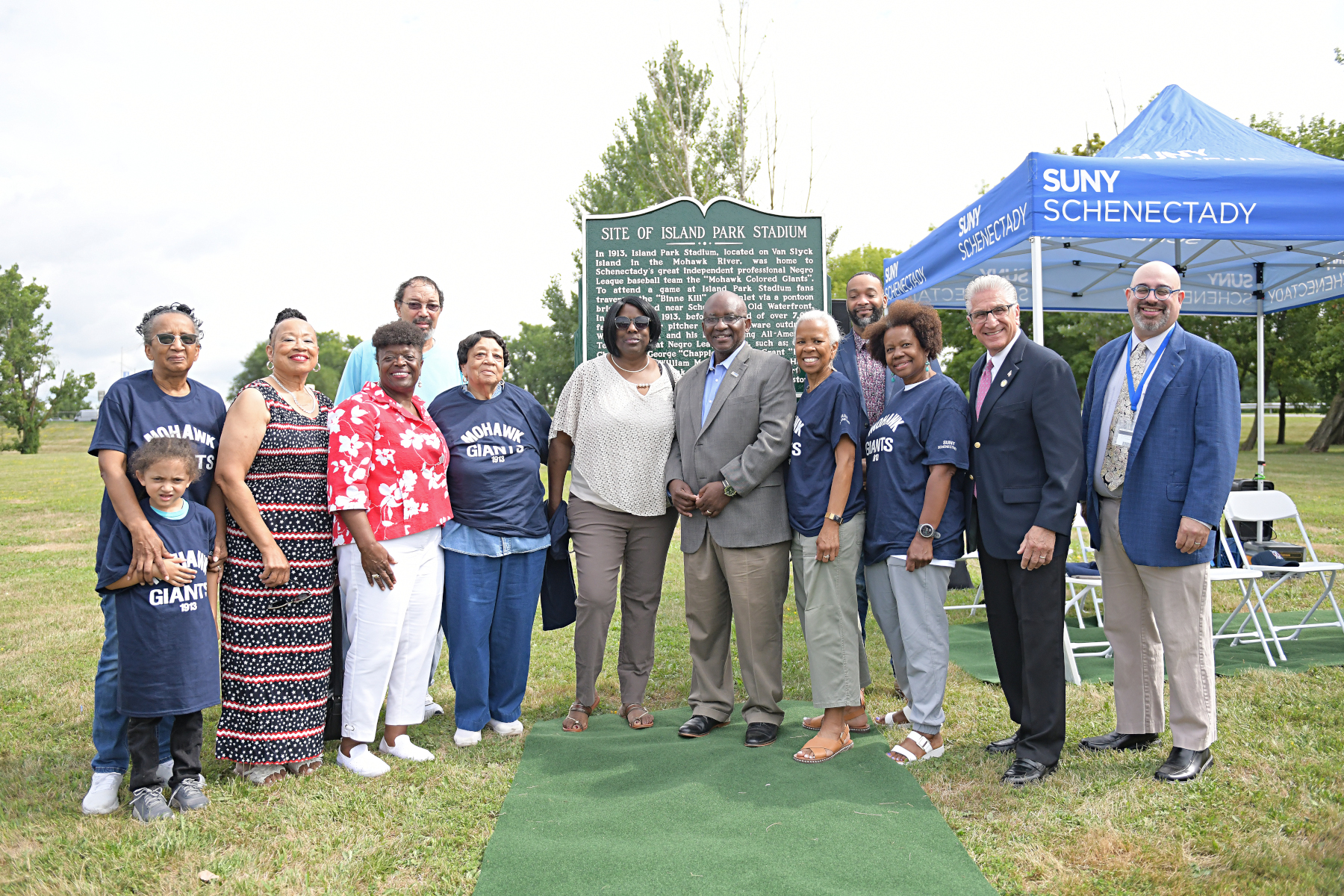 College officials and community leaders standing near historical marker