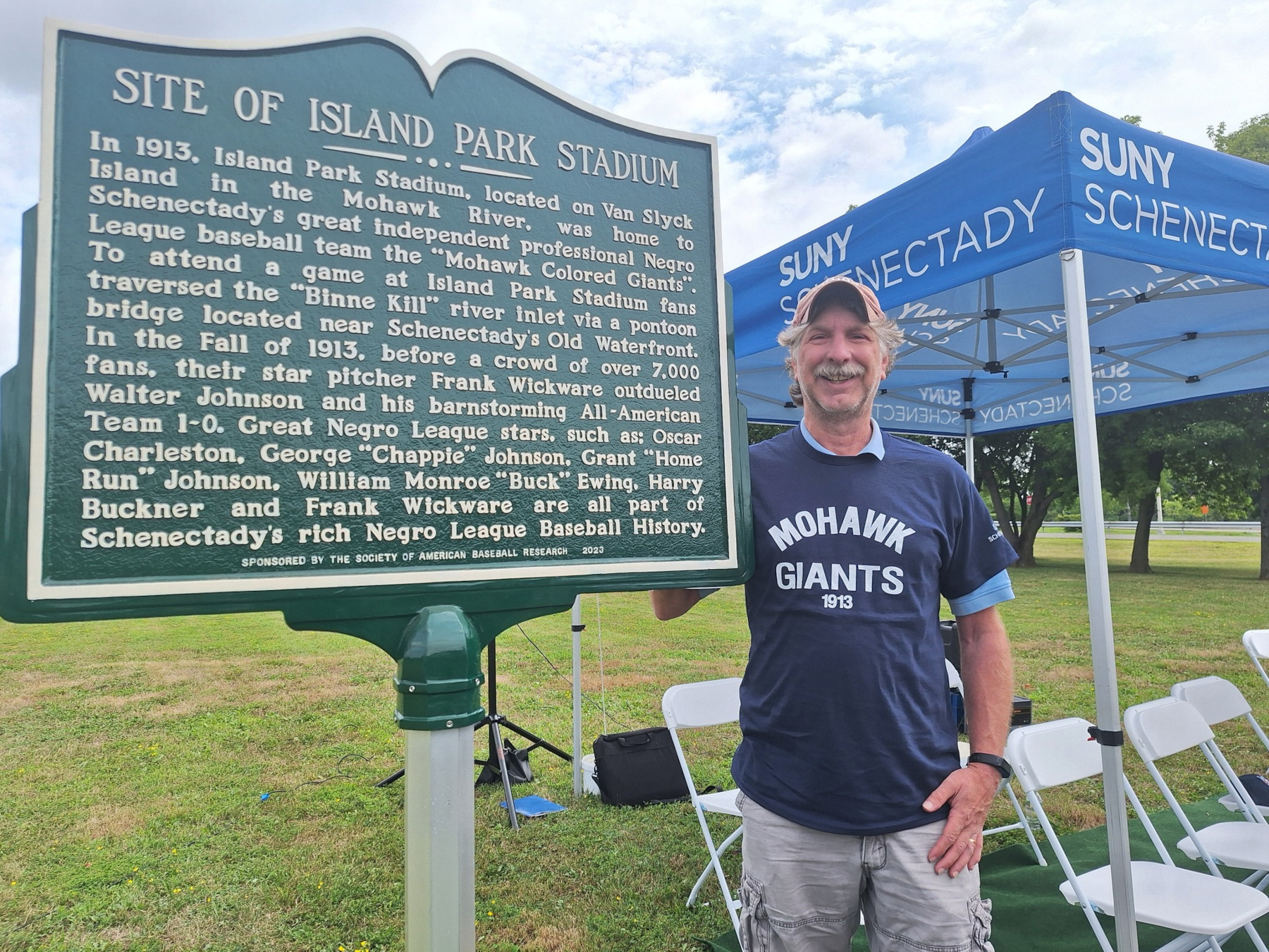 Baseball fan standing near historical marker