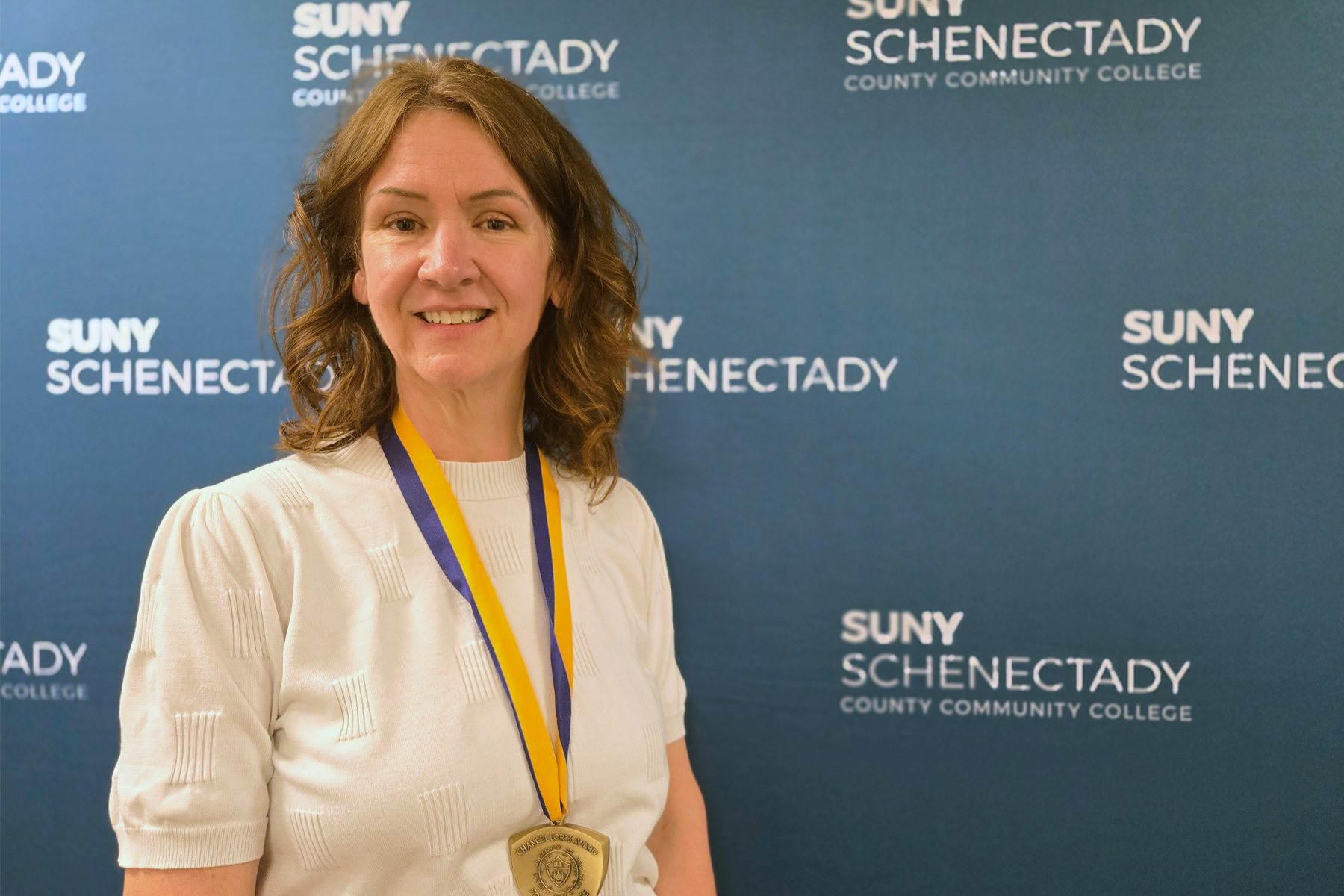 Carol Maimone wearing Chancellor's Award medallion