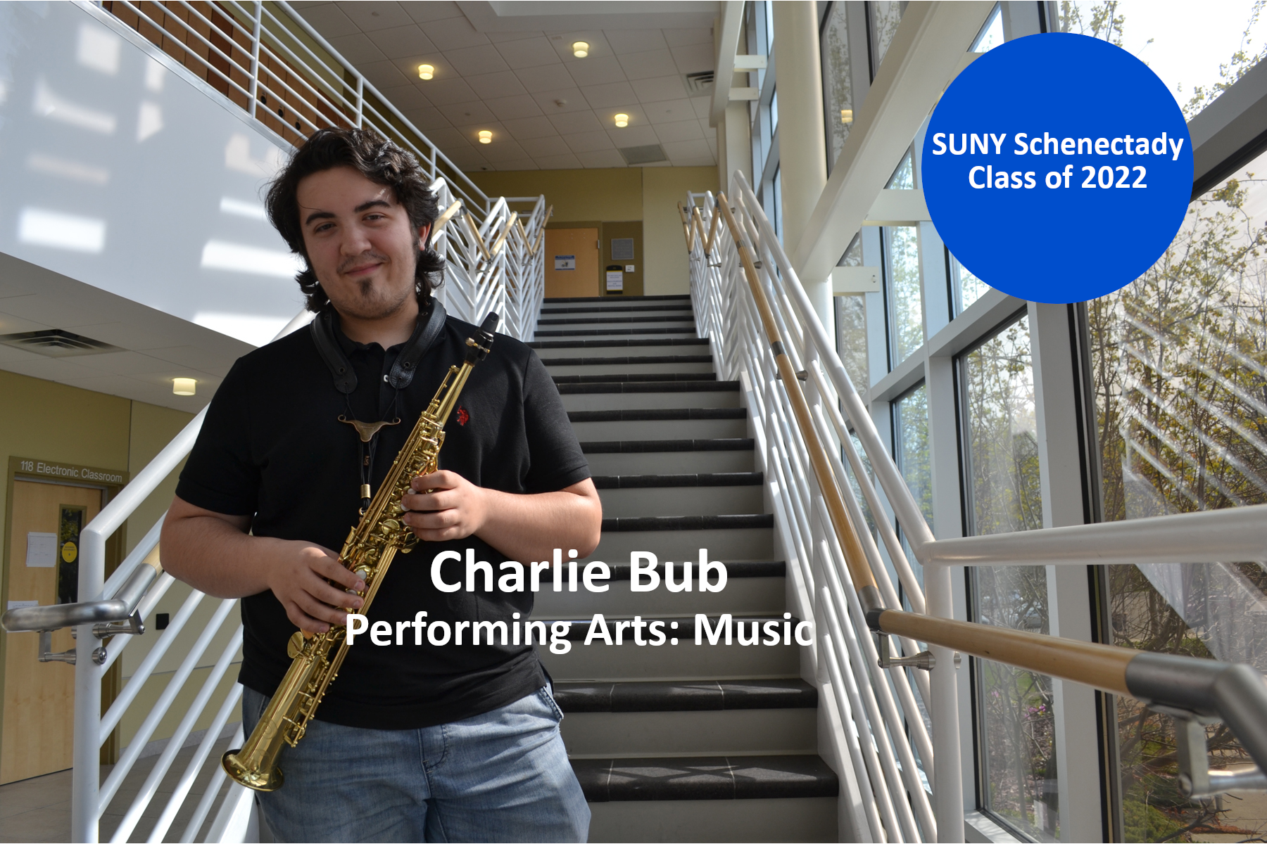 Charlie Bub holding saxophone, standing in School of Music