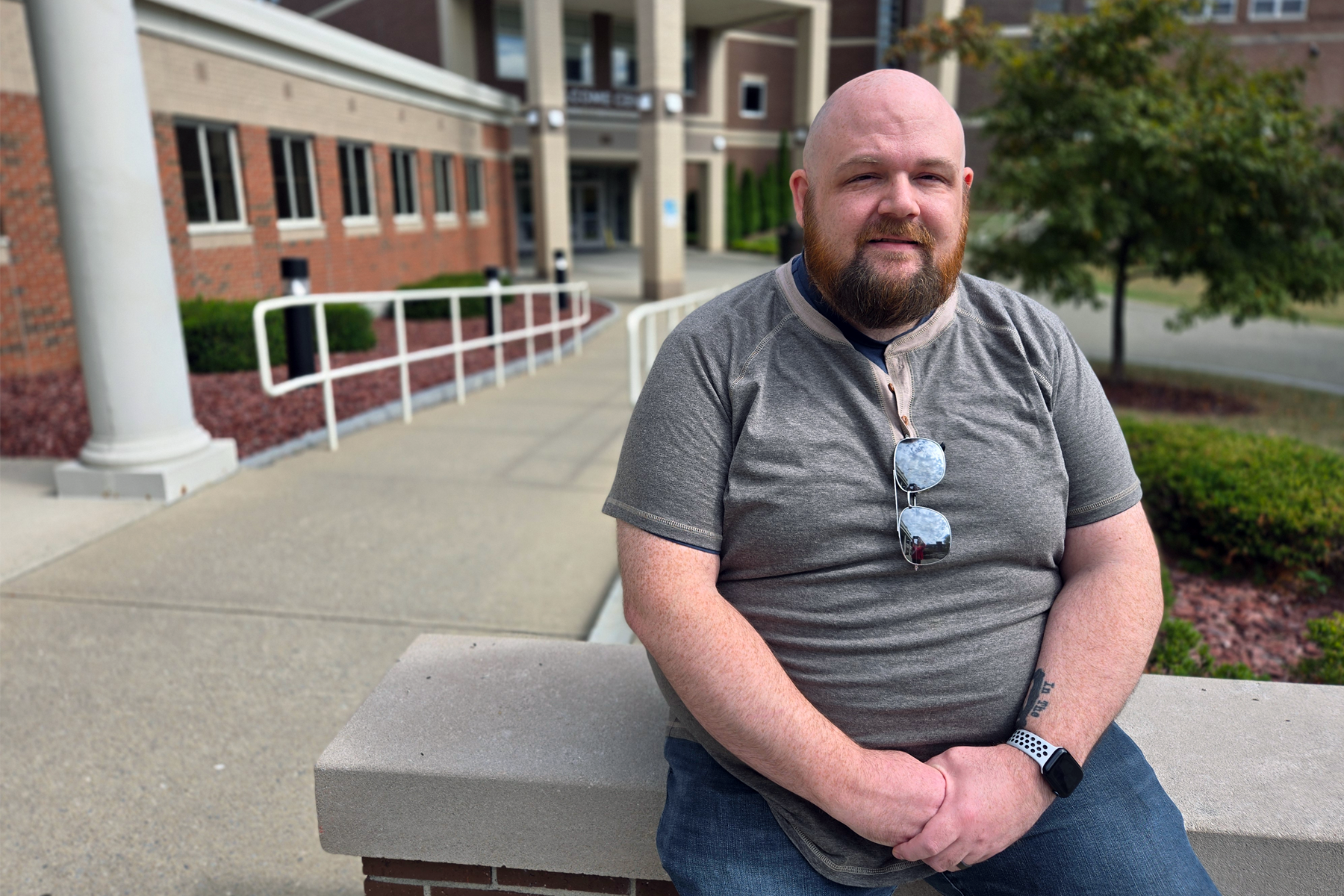 Christopher Davis, seated outside in the quad, Elston Hall behind him