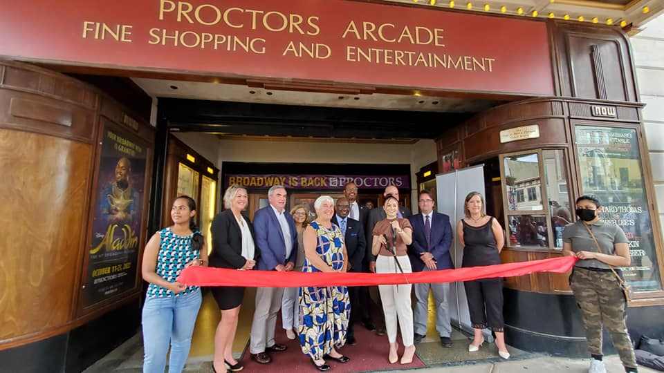 Officials cutting ribbon in front of Proctors