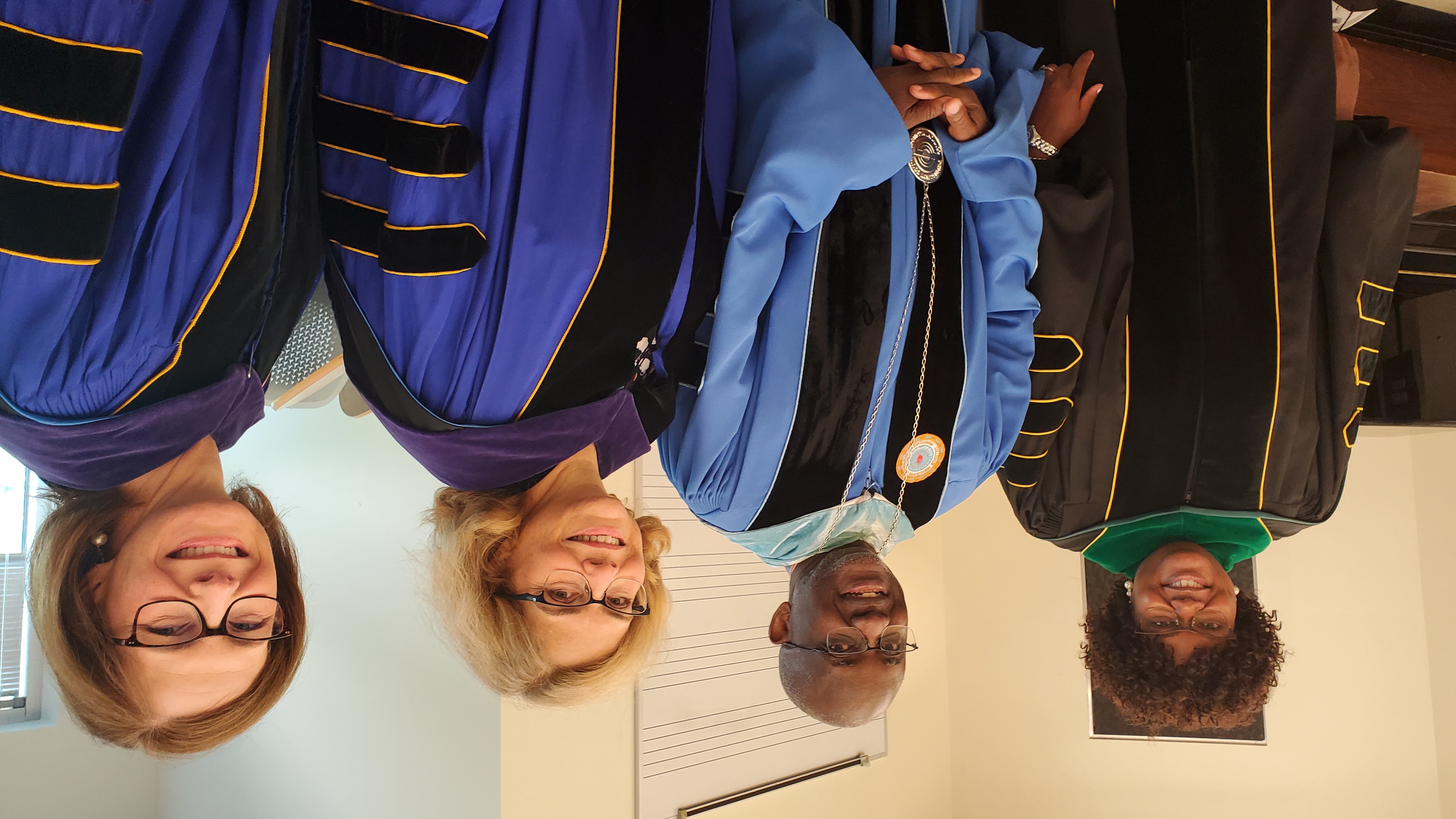 College officials and dignitaries standing inside before Commencement