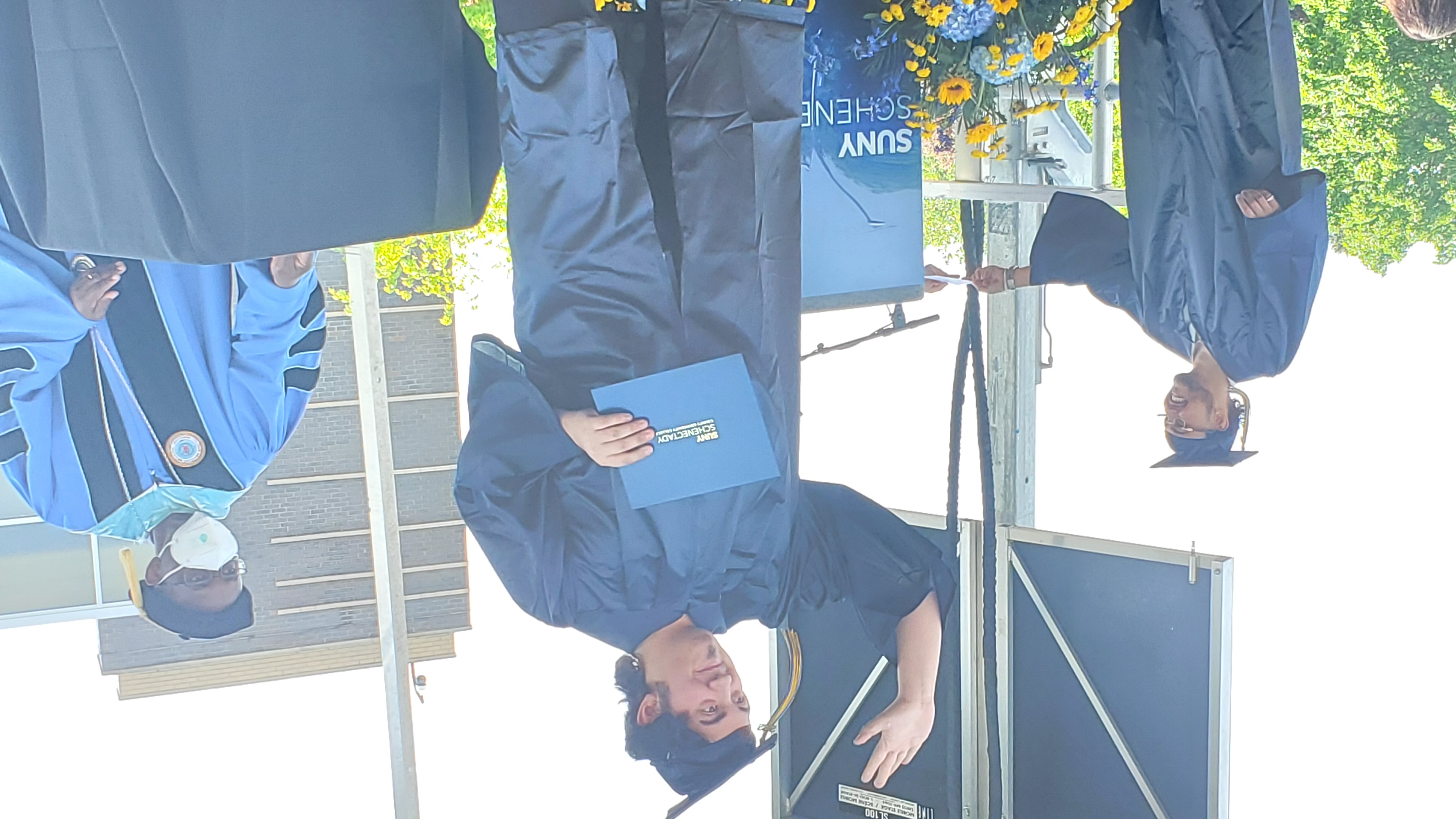 Charlie Bub, graduate, waving to audience from stage