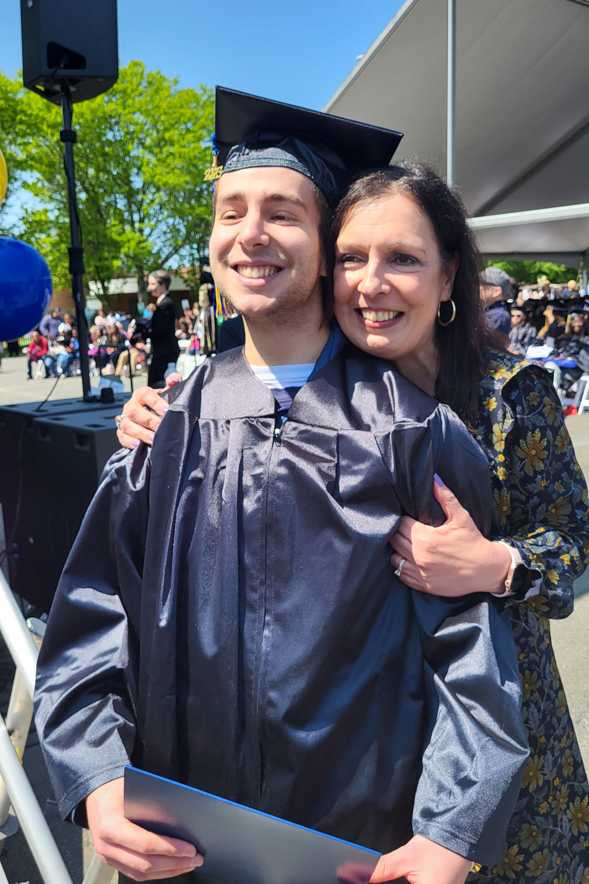 Family member hugging graduate who just crossed stage