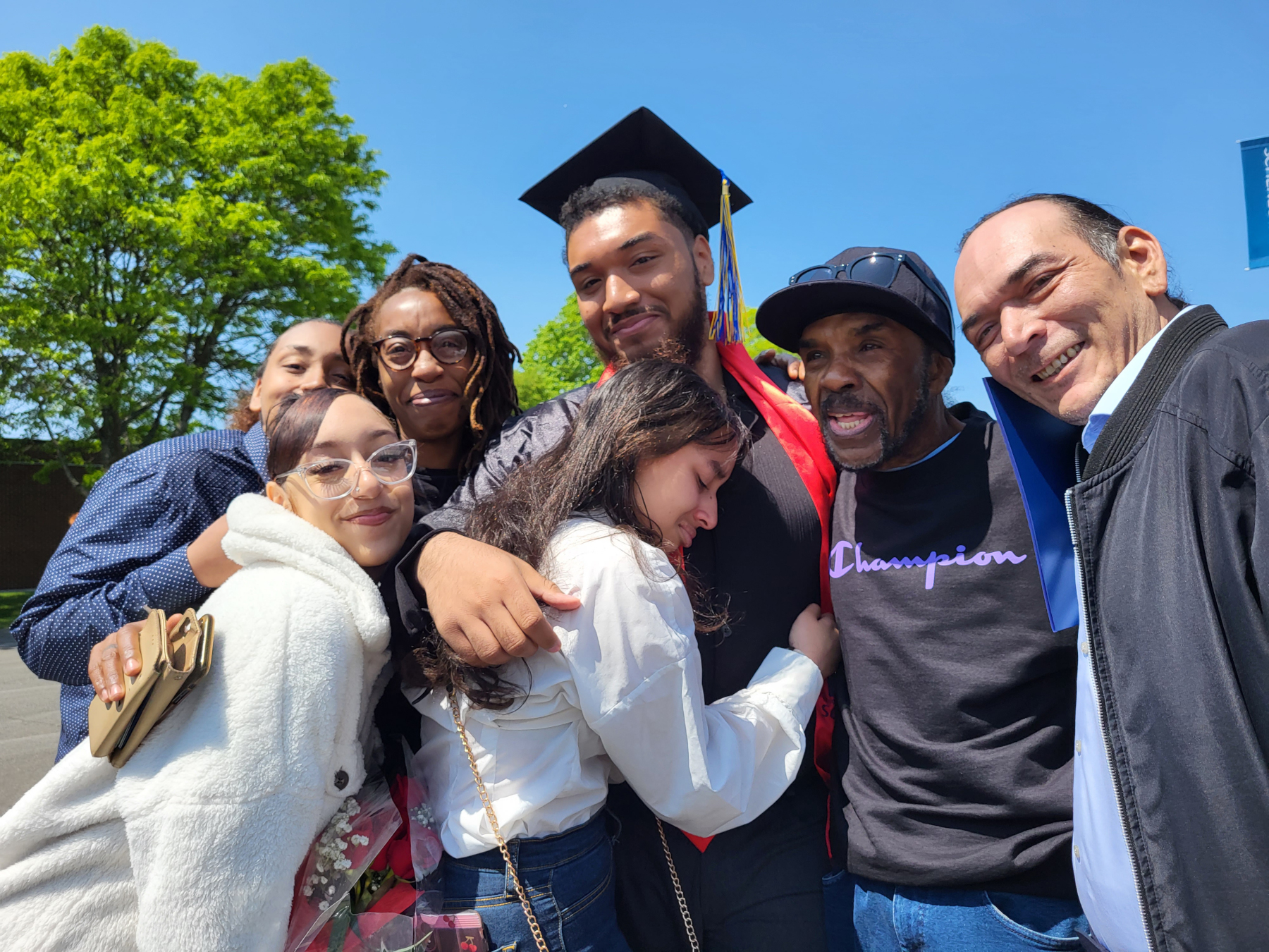 Graduate hugging family outside