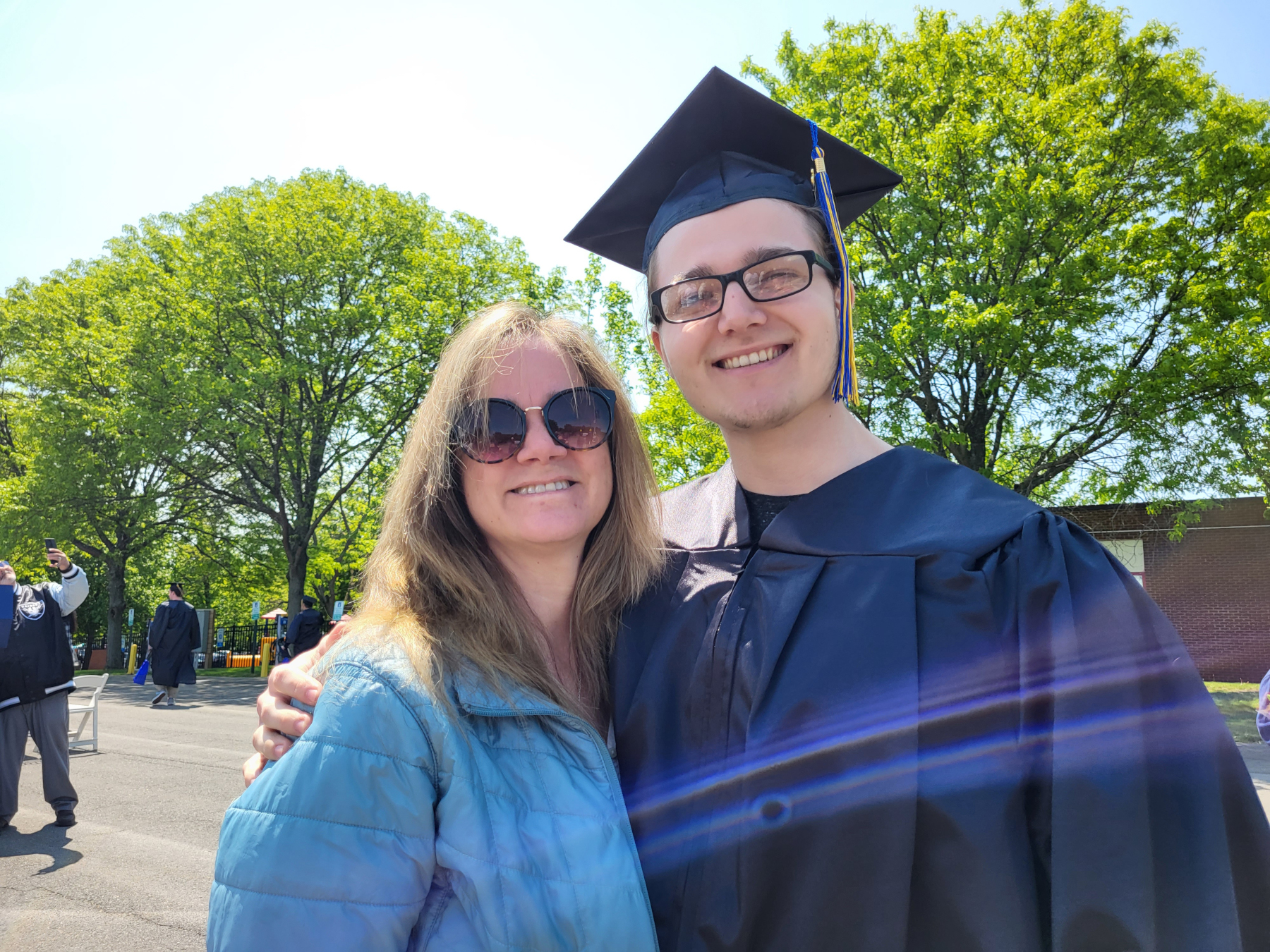 Graduate and mother, smiling outside