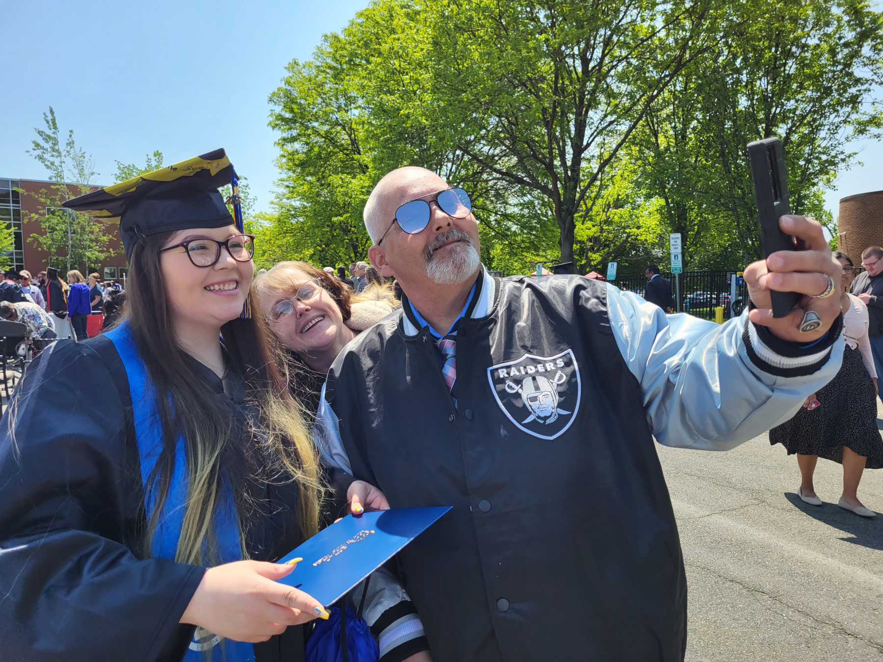 Graduate and family taking selfies outside